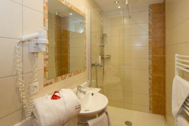 Badezimmer mit flachem Einstieg mit Glaswand, großem Spiegel, Waschbecken, Haarfön, WC separat