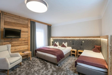 Die Dreibettzimmer im Stegerbräu bieten je nach Typ ein extra 3. Bett oder Sofabett für 3. Person. in Doppelbett und extra 3. Bett im Zimmer. Die Einrichtung mit Holz- und Loden oder klassich mit heller Buche