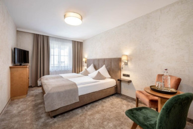 Doppelzimmer im Hotel Stegerbräu in Radstadt - Zimmeransicht mit Boxspringbett und Sitzplatz mit Tisch und 2 Stühlen. Wohnbeispiel, Ausstattung kann variieren.