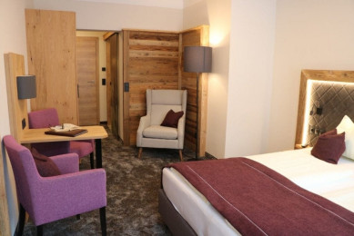 Einrichtungsbeispiel eines Doppelzimmers in der Komfort-Kategorie, alpin-elegantes Outfit mit Holzelementen