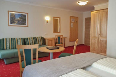 Teilansicht eines Vierbettzimmers mit extra Schlafcouch im Hotel Stegerbräu, Radstadt