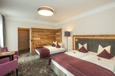 Die Zimmer im rechten Teil bieten Holz-und Lodenelemente und Boxspringbetten