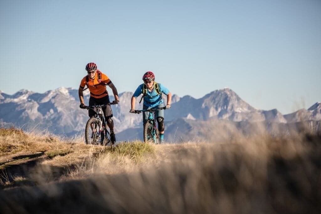 Mountainbiker auf dem Stoneman Taurista Anstieg zum Grießenkar mit Bergkulisse der Hohen Tauern im Hintergrund