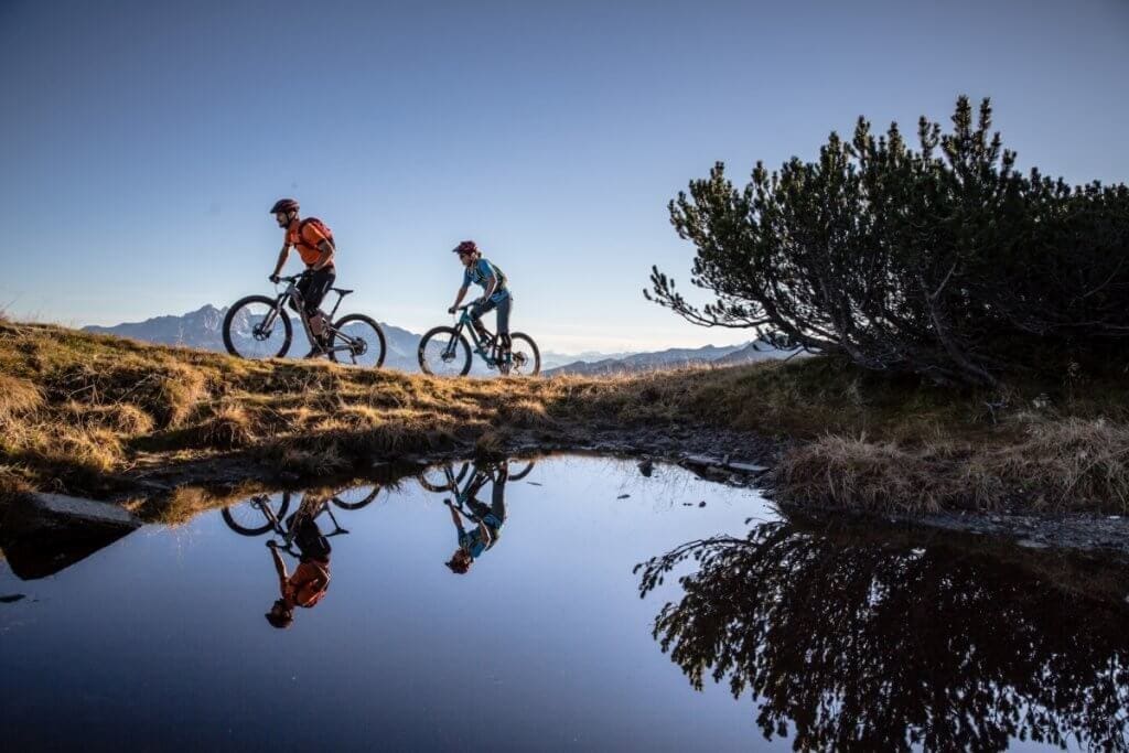 Mountainbiker am Stoneman Taurista Trail - Die Biker spiegeln sich im Wasser