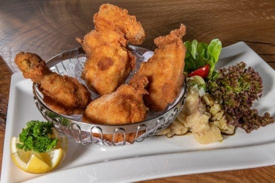 Das Backhendl wird im Stegerbräu traditionell mit Kartoffelsalat und Kernöldressing serviert