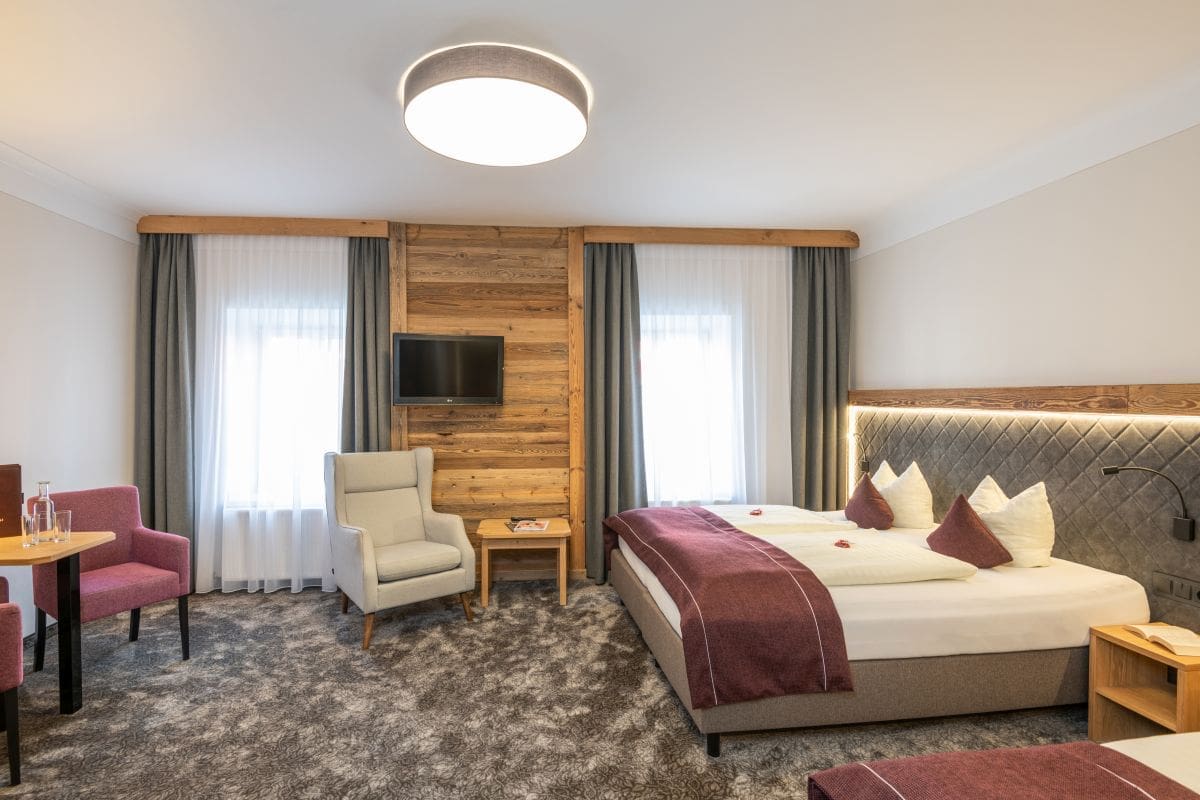 Die renovierten Zimmer im Stegerbräu präsentieren sich so wie hier, alpin-elegant mit viel Holz und Loden, oder klassisch in heller Eiche und mit neuem Badezimmer