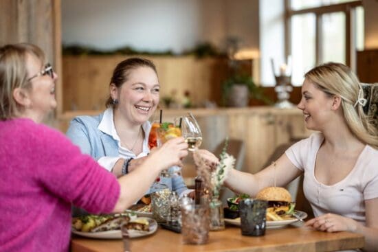 Gemeinsam genießen im Restaurant Stegerbräu Drei Frauen genießen gemeinsam Essen und Getränke im Restaurant Stegerbräu in Radstadt und stoßen miteinander an.