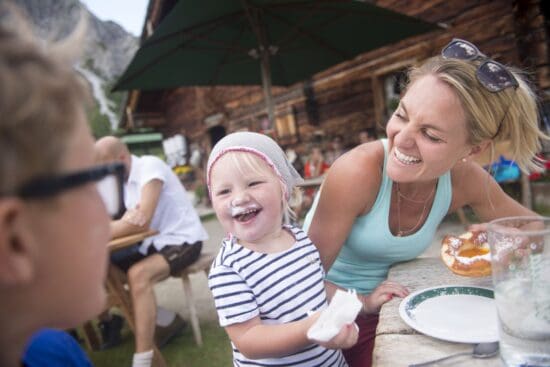 Herbst-Auszeit - Alm-Wandern ©TVB Radstadt - Hans Huber Fröhliche Familien-Auszeit auf der Alm im Bauernherbst. Ein Kind genießt einen süßen Bauernkrapfen