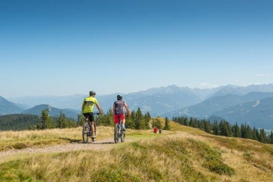 Mountainbiker treffen Wanderer am Hochplateau des Rossbrand, von wo man einen herrlichen Paoramablick auf 150 Gipfel hat
